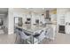 Kitchen island with granite countertops, gray bar stools, and stainless steel appliances at 5189 N 206Th Dr, Buckeye, AZ 85396