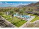 Resort-style pool area with palm trees, lounge chairs, and mountain views at 5189 N 206Th Dr, Buckeye, AZ 85396