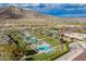 Aerial view of a community pool surrounded by palm trees, greenery, and desert landscape at 5189 N 206Th Dr, Buckeye, AZ 85396