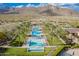 Multiple, resort-style pools with palm trees, lounge chairs, and desert mountain backdrop at 5189 N 206Th Dr, Buckeye, AZ 85396