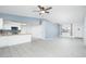 Bright living room featuring gray tile flooring, modern lighting, and an open floor plan to the kitchen at 562 W Keats Ave, Mesa, AZ 85210