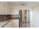 Bright kitchen featuring stainless steel refrigerator, granite countertops, and white cabinetry at 6223 N 12Th St # 8, Phoenix, AZ 85014