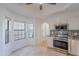 Eat-in kitchen area featuring white cabinets, stainless appliances, and travertine tile flooring at 6223 N 12Th St # 8, Phoenix, AZ 85014