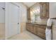 Well-lit bathroom with wood cabinets, granite counters, and decorative accents offers warmth and style at 6615 E Shea Blvd, Scottsdale, AZ 85254
