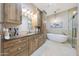 Modern bathroom featuring a soaking tub, walk-in shower, and custom vanity with storage at 6615 E Shea Blvd, Scottsdale, AZ 85254
