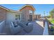 Inviting outdoor patio with comfortable seating, brickwork, and a charming view of the home's front entrance at 6615 E Shea Blvd, Scottsdale, AZ 85254