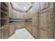 A large walk-in pantry is equipped with wrap-around custom shelving and solid surface countertops at 6615 E Shea Blvd, Scottsdale, AZ 85254