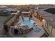 Backyard featuring a custom pool, grotto, and outdoor kitchen area for luxurious outdoor living at 7157 E Ivyglen Cir, Mesa, AZ 85207