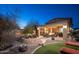 Inviting backyard with a covered patio, fire pit, and lush landscaping offers a relaxing space for outdoor living and entertaining at 7157 E Ivyglen Cir, Mesa, AZ 85207