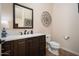 Elegant half bathroom with a decorative mirror and sleek fixtures at 7157 E Ivyglen Cir, Mesa, AZ 85207