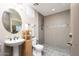 Well-lit bathroom featuring a modern sink, tile-lined shower, and neutral color palette at 7157 E Ivyglen Cir, Mesa, AZ 85207