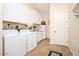 Well-lit laundry room boasts white cabinets and a utility sink for added convenience at 7157 E Ivyglen Cir, Mesa, AZ 85207