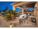 Outdoor kitchen features a built-in grill, bar seating, and lush landscaping, perfect for alfresco dining and entertaining at 7157 E Ivyglen Cir, Mesa, AZ 85207