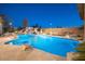 Backyard pool area with stone features, slide, waterfall, and lush landscaping at 7157 E Ivyglen Cir, Mesa, AZ 85207