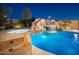 Backyard pool area with stone features, slide, waterfall, and lush landscaping at 7157 E Ivyglen Cir, Mesa, AZ 85207
