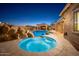 Stunning backyard with a sparkling pool, hot tub, and rock waterfall feature creating an oasis for relaxation and enjoyment at 7157 E Ivyglen Cir, Mesa, AZ 85207