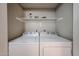 Bright laundry room featuring a white washer and dryer with storage shelf above at 750 E Northern Ave # 1079, Phoenix, AZ 85020