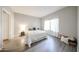 Bedroom with light-colored wood-look floors, neutral walls, and large window with sheer white curtains at 750 E Northern Ave # 1079, Phoenix, AZ 85020