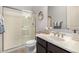 Bathroom featuring a glass enclosed shower, a vanity with sink and a round mirror at 7576 W Quail Ave, Glendale, AZ 85308