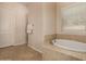 Bright bathroom featuring a soaking tub, walk-in shower, and elegant tile work at 7576 W Quail Ave, Glendale, AZ 85308