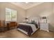 Cozy bedroom with a plush bed, neutral tones, and a bright window at 7576 W Quail Ave, Glendale, AZ 85308