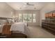 Bedroom features a bed, bureau, large windows with neighborhood views, and a ceiling fan at 7576 W Quail Ave, Glendale, AZ 85308