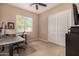 Neutral bedroom with a ceiling fan, a home office setup and double door closet at 7576 W Quail Ave, Glendale, AZ 85308