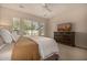 Bedroom featuring a large window with neighborhood views, a ceiling fan, and neutral-colored furnishings at 7576 W Quail Ave, Glendale, AZ 85308