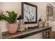 Rustic console table displaying decorative lanterns, a floral painting, and a potted plant at 7576 W Quail Ave, Glendale, AZ 85308