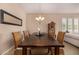 Bright dining room with dark wood table, woven chairs, and modern chandelier for elegant dining at 7576 W Quail Ave, Glendale, AZ 85308