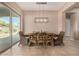 Dining area with wood table, wicker chairs, and large sliding glass doors to the patio for indoor-outdoor dining at 7576 W Quail Ave, Glendale, AZ 85308