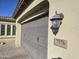 Attached two-car garage featuring a gray door with a stone address marker at 7576 W Quail Ave, Glendale, AZ 85308