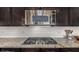 Close-up of kitchen stove, microwave, and backsplash, showcasing modern appliances and design elements at 7576 W Quail Ave, Glendale, AZ 85308