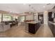 Open kitchen with large island, dark cabinets, and seamless flow into the living and dining areas at 7576 W Quail Ave, Glendale, AZ 85308