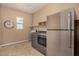 A neutral laundry room featuring stainless steel appliances and tile flooring at 7576 W Quail Ave, Glendale, AZ 85308