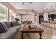 Open-concept living room featuring a cozy couch, coffee table, kitchen bar, and dining area for seamless entertaining at 7576 W Quail Ave, Glendale, AZ 85308