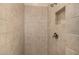 Neutral toned tile shower with built in soap niche and brushed metal shower head at 7576 W Quail Ave, Glendale, AZ 85308