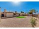 A gravel backyard, including a small patch of grass, with exterior views of a desert home at 836 W Watson Dr, Tempe, AZ 85283