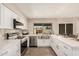 Bright kitchen featuring stainless steel appliances and white cabinets, offers great views of the backyard at 836 W Watson Dr, Tempe, AZ 85283