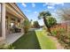 Serene backyard view with a covered patio, manicured lawn, lush garden, and a refreshing pool at 9098 N 117Th Way, Scottsdale, AZ 85259