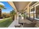 Inviting covered patio with wicker seating, outdoor dining area, and views of the lush lawn at 9098 N 117Th Way, Scottsdale, AZ 85259