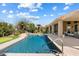 Inviting pool area with waterfall feature, lush landscaping, and a putting green in the distance at 9098 N 117Th Way, Scottsdale, AZ 85259
