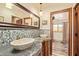 Bathroom vanity featuring dual vessel sinks, a large mirror, mosaic backsplash, and mountain views at 9121 W Quail W Trl, Queen Creek, AZ 85144