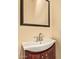 Classic bathroom featuring a white sink, dark cabinets, and a well-lit vanity mirror at 9121 W Quail W Trl, Queen Creek, AZ 85144