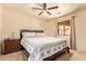 Cozy bedroom with a ceiling fan, floral bedding, and a window view at 9121 W Quail W Trl, Queen Creek, AZ 85144