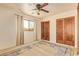 Spacious bedroom featuring a ceiling fan, wood closet doors, and a window view at 9121 W Quail W Trl, Queen Creek, AZ 85144