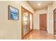 Hallway featuring a wood-look floor, paneled french doors, and a decorative painting at 9121 W Quail W Trl, Queen Creek, AZ 85144