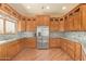 Spacious kitchen featuring wood cabinets, stainless steel appliances, and a mosaic tile backsplash at 9121 W Quail W Trl, Queen Creek, AZ 85144