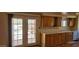 Shows a kitchen area with wood look floors, wood cabinets, and glass doors that look out to a yard at 9121 W Quail W Trl, Queen Creek, AZ 85144