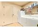 Functional laundry room with washer, dryer, and storage shelves for convenience at 9121 W Quail W Trl, Queen Creek, AZ 85144